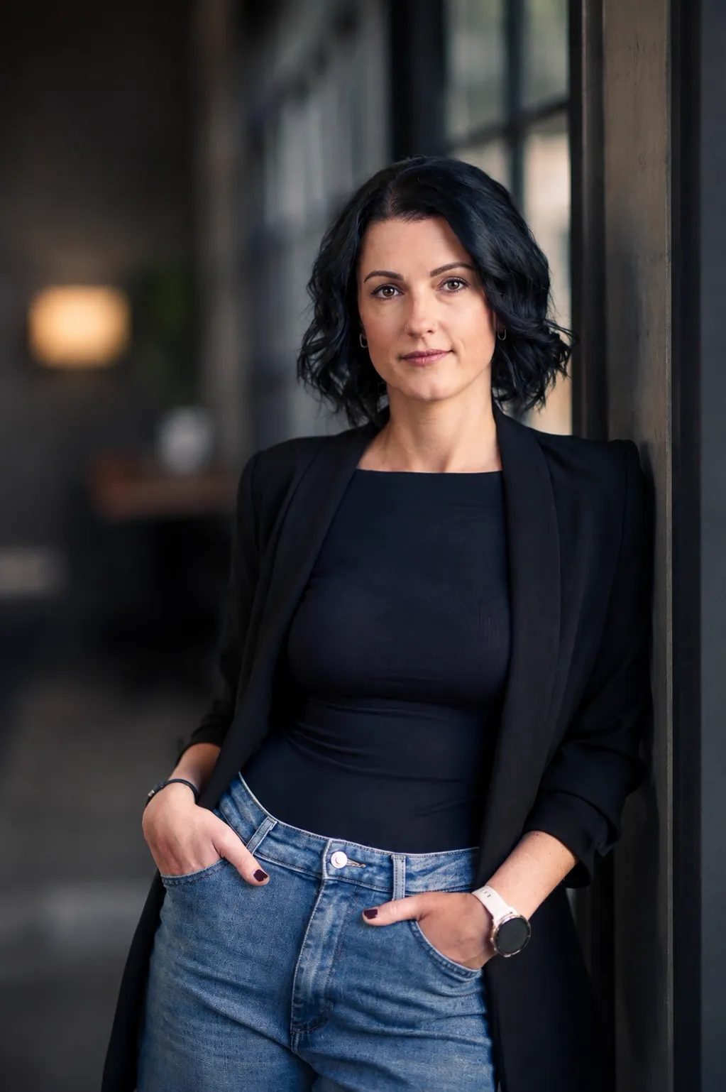 Business Portrait einer Frau an einem Türrahmen